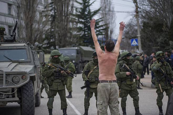 Ukrainalainen mies protestoi naamiotuneiden sotilaiden edessä  Sevastopolin kaupungissa Krimillä maaliskuussa 2014.